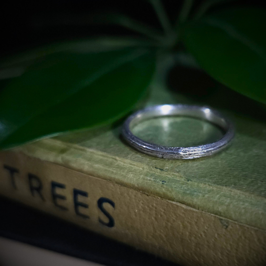 Sterling silver ring on a book titled 'TREES' with green leaves in the background.

The twig has deep longitudinal ridges on the outside and a smooth inside edge.