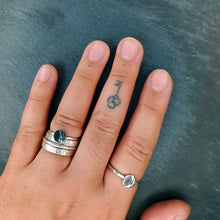 Load image into Gallery viewer, Riley wears one Luna ring stacked with his wedding bands and one alone on his forefinger. His nails are short and there&#39;s a small tattoo of a key on the last knuckle of his middle finger.
